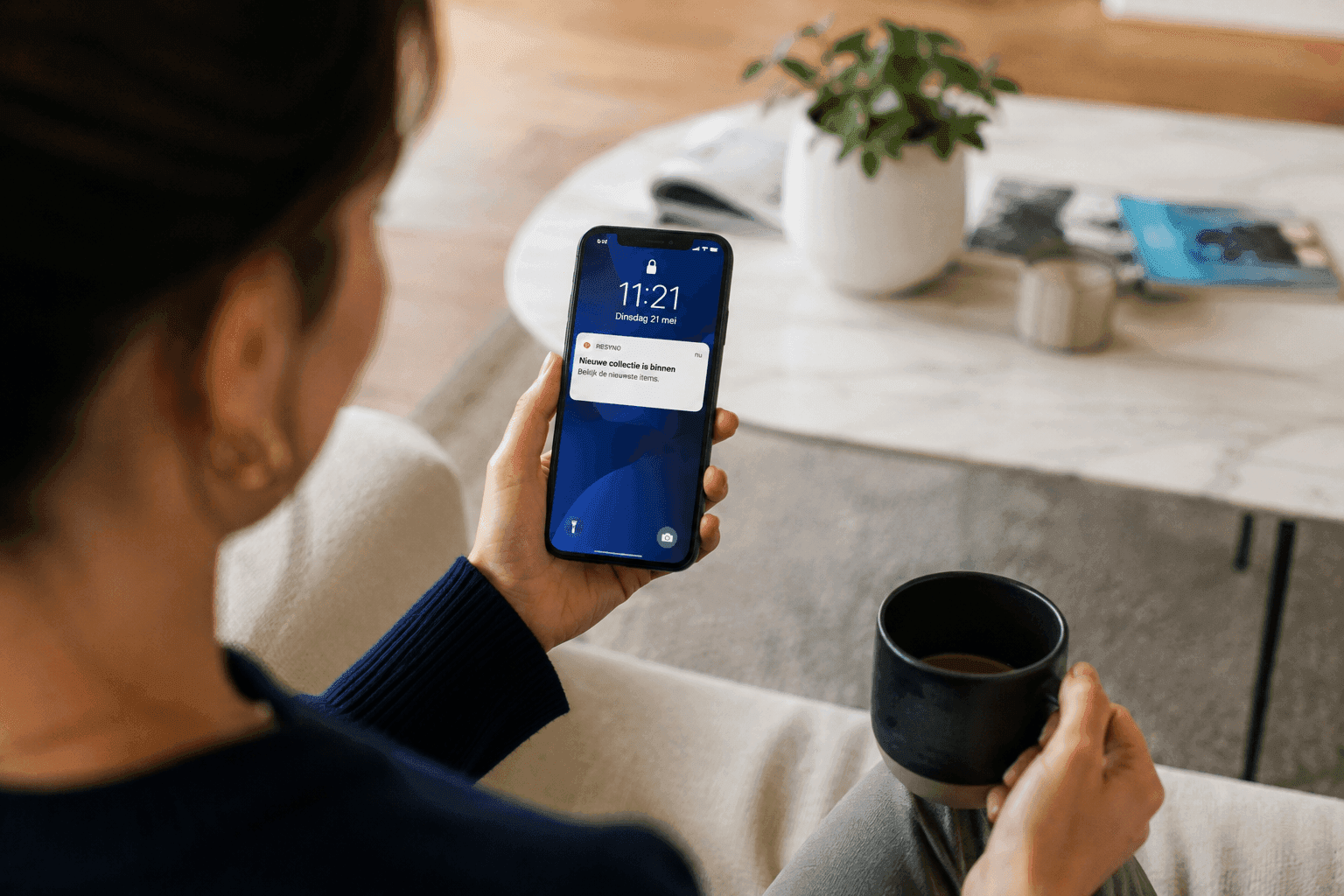 Een klant bekijkt een melding over een nieuwe collectie op haar telefoon
